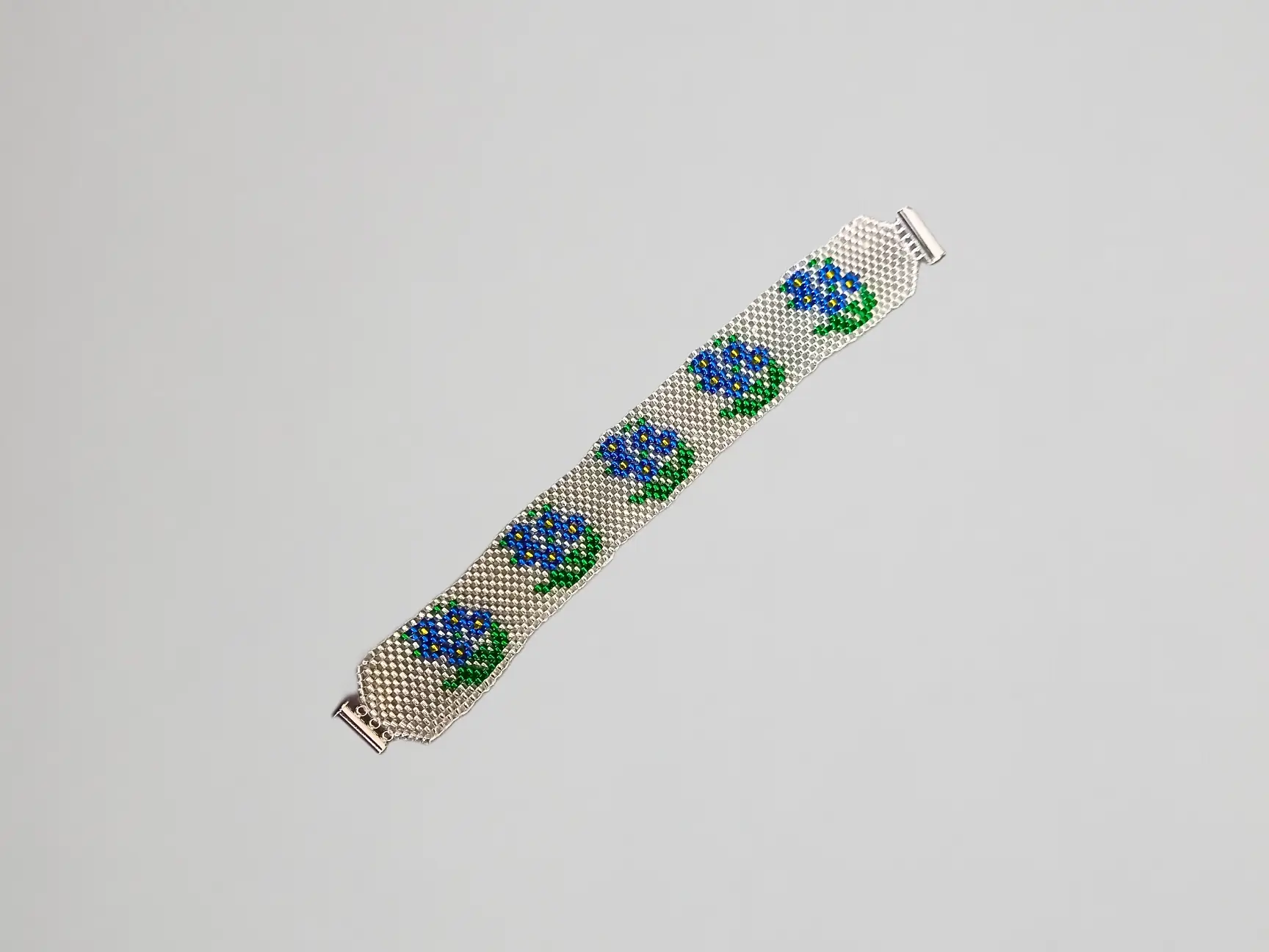 Bracelet en perles fait main avec motif de fleurs myosotis bleues et vertes sur fond argenté