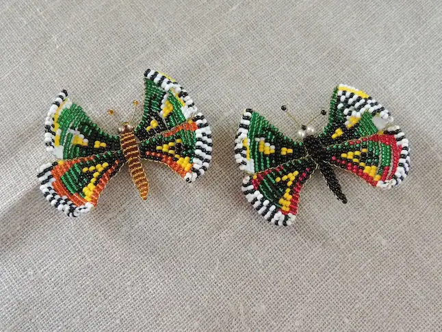 Papillons artisanaux en perles avec motifs géométriques.
