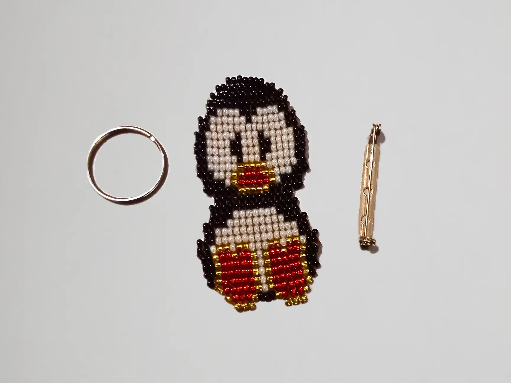 Pingouin 2D en perles noires, blanches et rouges, tissé à la main, création artisanale belge. Options porte-clé ou broche