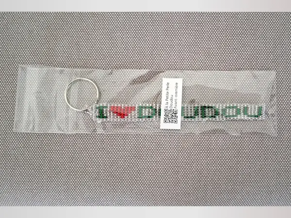 Porte-clés artisanal en perles de rocaille I Love Doudou dans son emballage avec un QR code À la petite perle.